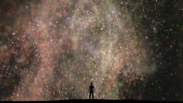 The man stands among the flying shimmering particles. slow motion