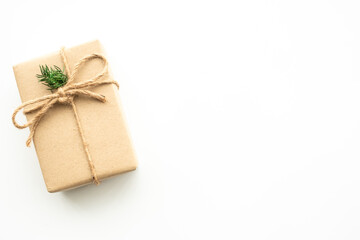 Brown gift box with festive decoration for Christmas and new year is on white background. Top view with copy space, flat lay.