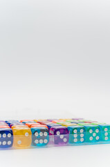 box of multicolored dice on a white background with text space