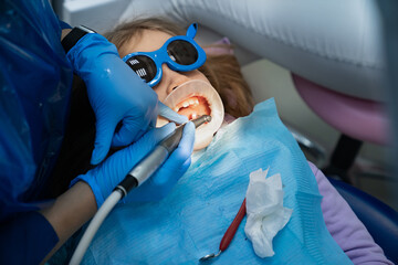 little girl with oral dilator at dentist's appointment. treatment of teeth