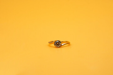 Solitaire engagement ring round cut yellow background	