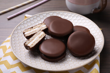 Tasty choco pies on wooden table. Snack cakes