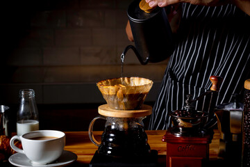 Coffee shop concept : Professional barista preparing coffee using chemex pour over coffee maker and...