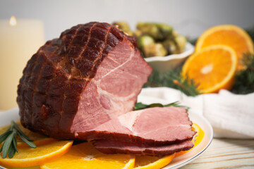 Delicious ham served with orange and rosemary on white wooden table, closeup