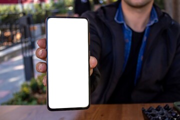Man showing smartphone with blank white screen.