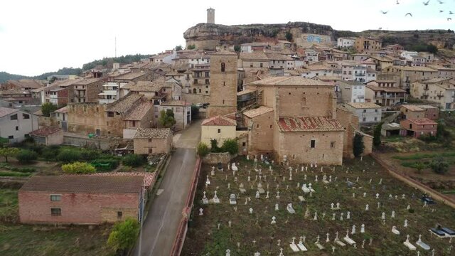 Aerial top view towards the clock tower and the cemetery of  the small village of Monroyo in Matarra&ntilde;a region in Spain_4