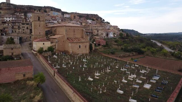 Drone view towards the clock tower and above the cemetery and the small village of Monroyo in Matarra&ntilde;a region in Spain_3