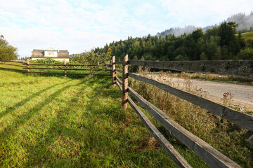 Fototapeta na wymiar Beautiful view with wooden fence near road