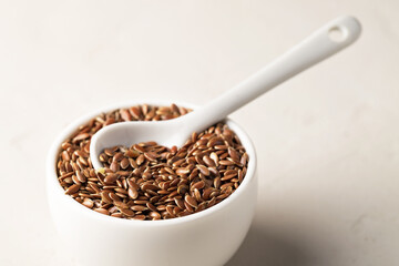 Flax seeds in a bowl on a light background. Selective focus. Close-up.
