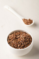 Flax seeds in a bowl on a light background. Selective focus. Close-up.