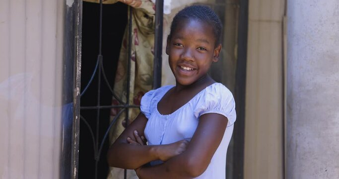 Poverty. Inequality. Young Black African girl doing schoolwork in a shack in a township