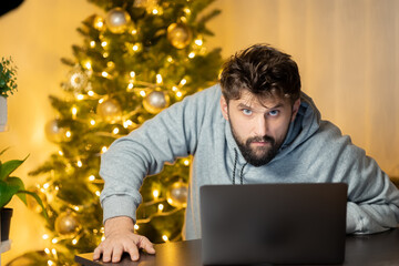 on the night before christmas, the tortured man works at the laptop in the office