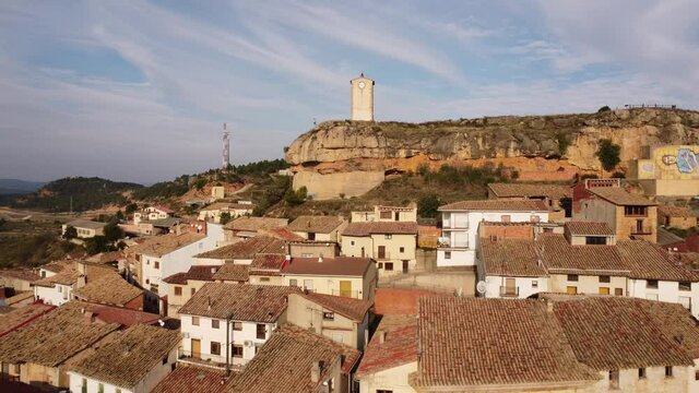 Drone view towards the clock tower and above the small village of Monroyo in Matarra&ntilde;a region in Spain