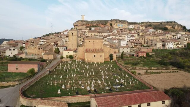 Drone view towards the clock tower and above the cemetery and the small village of Monroyo in Matarra&ntilde;a region in Spain