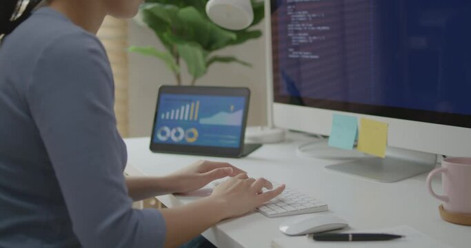 Asia young business woman sit busy at home office desk work code on desktop PC reskill upskill for job career remote self test IT deep tech ai design skill online html text for cyber security.