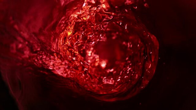 Super slow motion of pouring red wine in twister shape. Filmed on high speed cinema camera