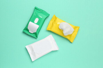 Wet wipes flow packs on turquoise background, flat lay