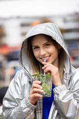 Attractive young woman or twentysomething girl drinking mojito with straw in city center during happy hour. High quality photo