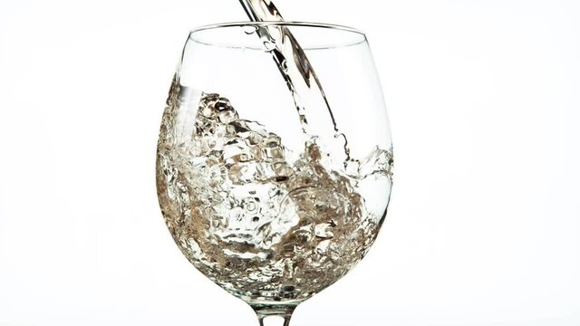 Super slow motion of pouring white wine in detail, isolated on white background. Speed ramp effect. Filmed on high speed cinema camera, 1000 fps