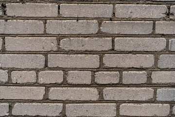The weathered texture of old dirty white and gray brick wall background. Building. Copy space