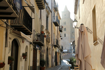 Glimpse of Cefalu historical town with cathedral tower on backgroun, Sicily, Italy