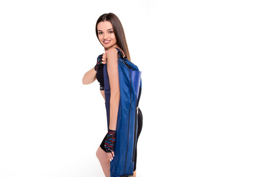 Brunette Girl Athlete Smiling And Standing With A Blue Carpet For Yoga On A White Background