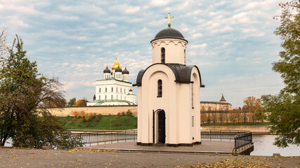 old chapel on the banks of the Velikaya river against the background of the cathedral and the blue sky. Pskov. Russia