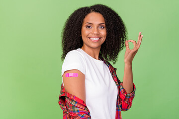 Photo of young african woman make vaccination show okey symbol advert advise recommend isolated...