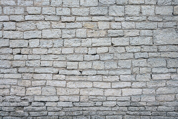 old brick wall made of limestone blocks of different sizes as the background