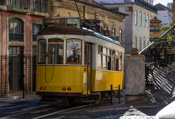 Fototapeta na wymiar Old tram running down street of Lisbon's old town