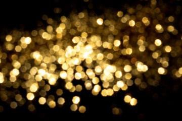 Golden blurred bokeh lights on black background. Glitter sparkle stars for celebrate. Overlay for your design