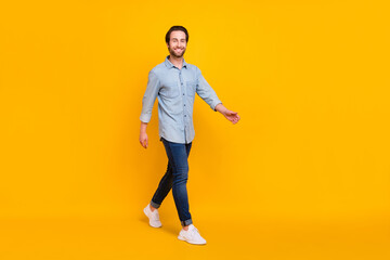 Fototapeta na wymiar Full body profile side photo of young handsome man happy positive smile go walk step isolated over yellow color background