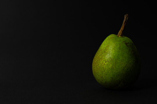 Green pear on a black background