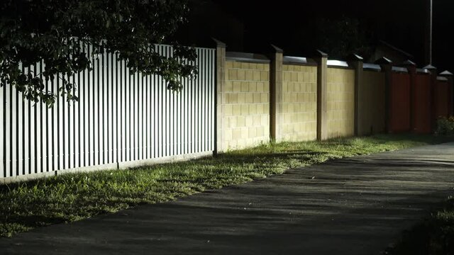 Thief in balaclava mask steals TV and funny runs away, at night in a private sector, townhouse, security system and robbery concept