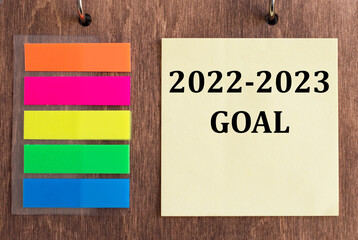 2022, 2023 coal text on a yellow card on a wooden background next to colored stickers