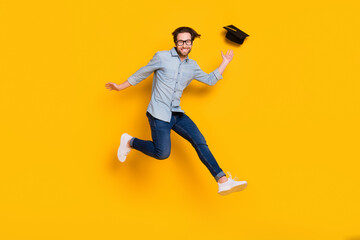 Fototapeta na wymiar Full body profile side photo of young man happy positive smile fly air fall mortarboard jump up isolated over yellow color background
