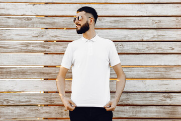 stylish man with beard, stands on a wooden background with copy space for your text message or advertisement