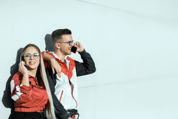 Two young people talking on their phones, telecommunication concept