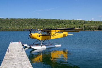 Fototapeta na wymiar Yellow seaplane tied to a dock at Gore Bay on Manitoulin Island