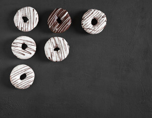 Chocolate and white Donuts in the corner on dark background