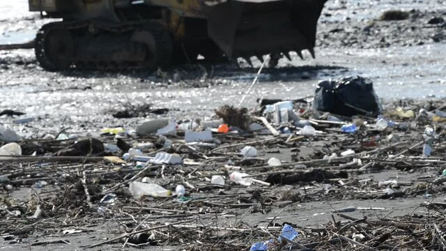 the beach invaded by waste and plastic after heavy rains and storms on the Mediterranean island