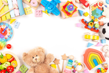Fototapeta na wymiar Baby kids toys frame on white background. Teddy bear and many colorful educational wooden, plastic toys. Top view, flat lay, copy space for text