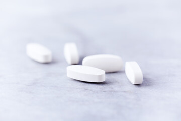 Beta - Alanine tablets. A dietary supplement on bright stone background. Soft focus. Close up. Copy space.  