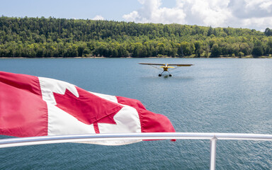 Canadian flag and a seaplane on a tree lined bay on Manitoulin Island at Gore Bay, Ontario, Canada
