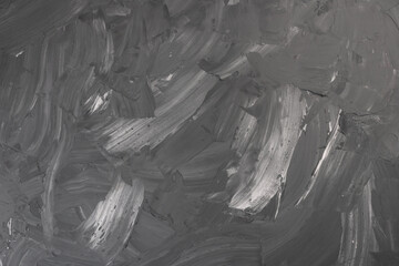 Abstract background. White paint and black ink texture. Macro image of spackling paste. Stroke wallpaper for web and game design. Drywall mud art. Smear of painterly plaster on cardboard.