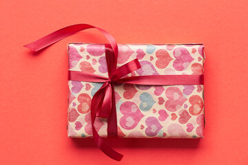 Valentine's day gift on red background, copy space, closeup, from above overhead top view, monochrome holiday background for your design