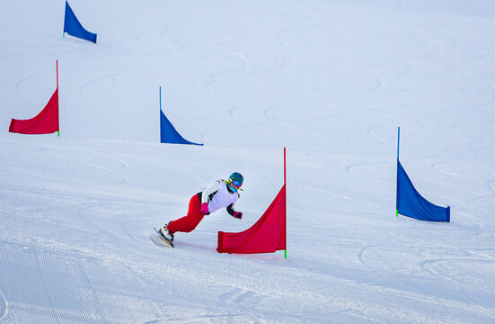 athlete girl with a hard snowboard for slalom in a ski resort enters the turn, Murmansk region, Russia.
