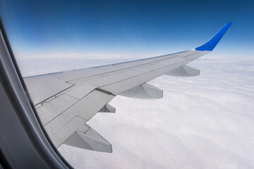 Obraz premium aircraft wing from the aircraft window overlooking the blue sky and beautiful clouds
