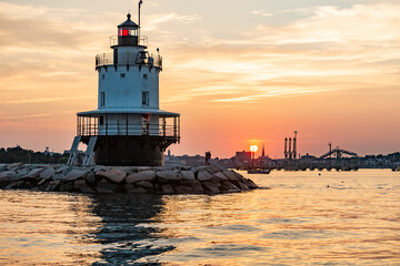South Portland Breakwater lighthouse, also known as Bug light, guides a fishing trawler into the...