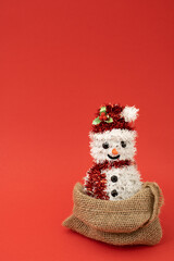 Christmas and chinese new year scene, creative snow man in retro bag with happy red background. Xmas decoration concept with copy space. Minimal colored with simple retro pop art decoration.